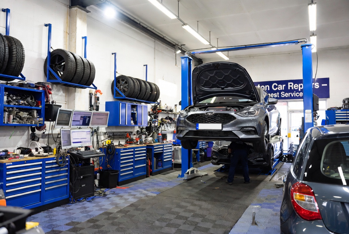 Split-scene comparison showing a frustrated driver holding an expensive main dealer invoice next to a smiling mechanic from Homerton Car Repairs in Hackney holding a tablet with a fixed-price affordable quote.